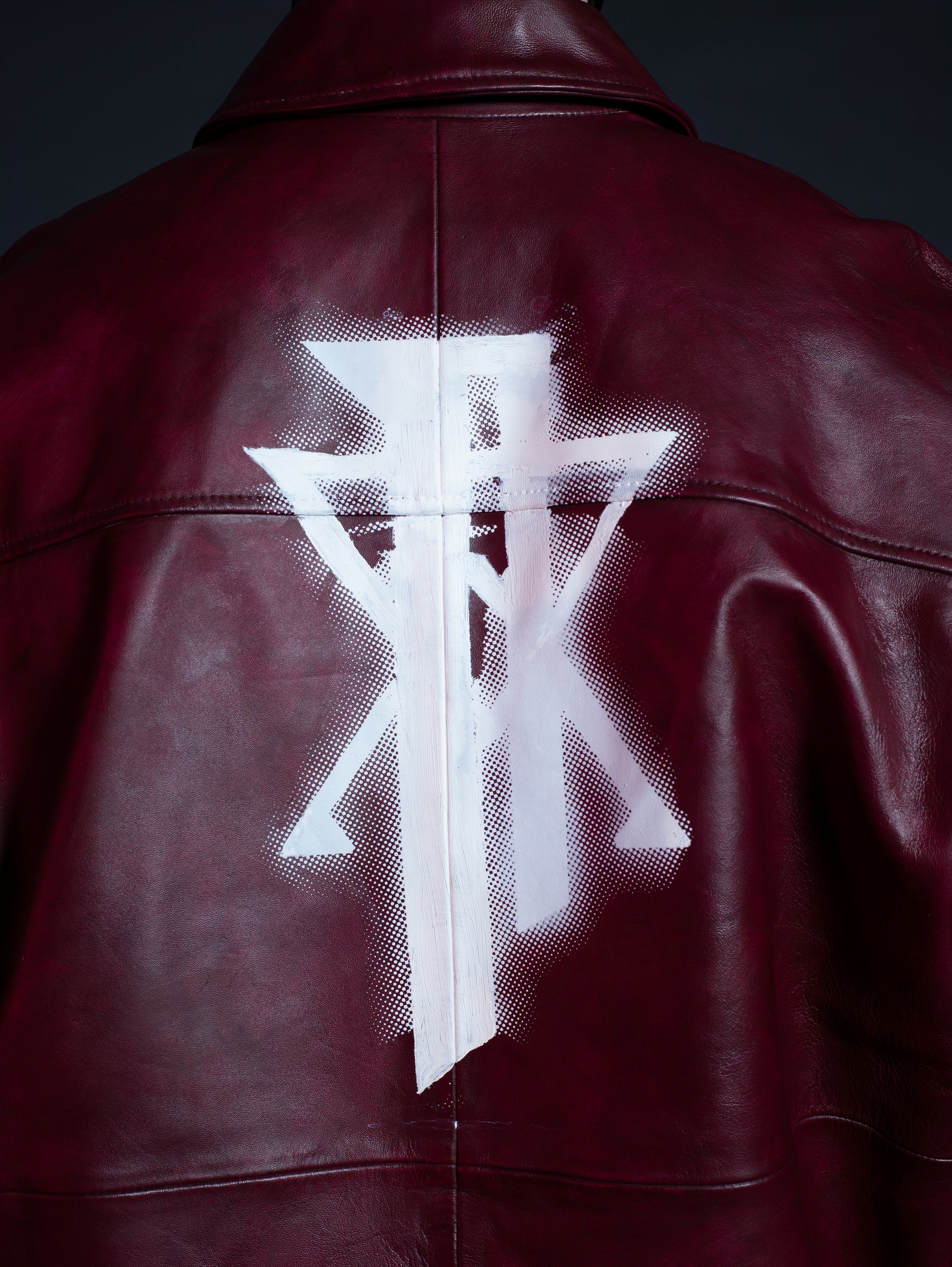 Close-up of matte hand-dyed leather texture on burgundy streetwear jacket