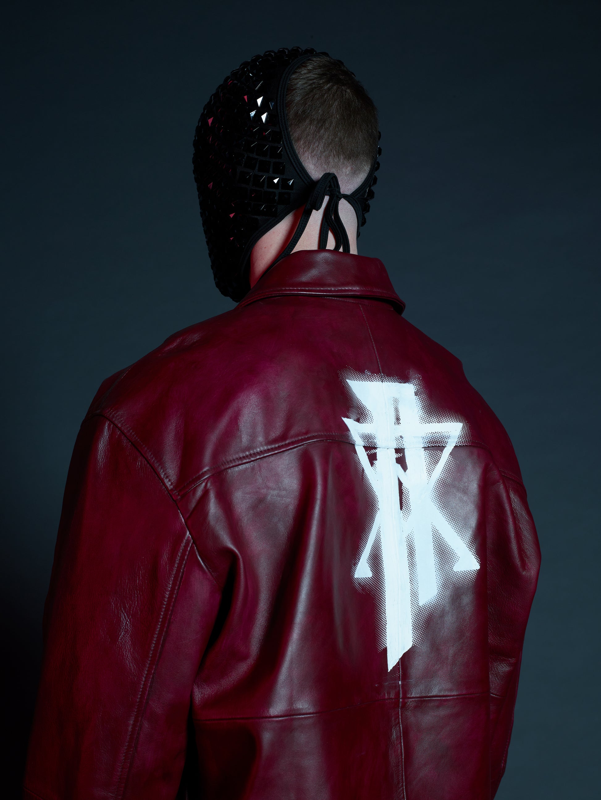 Back view showing half-tone screen-printed logo on leather streetwear jacket