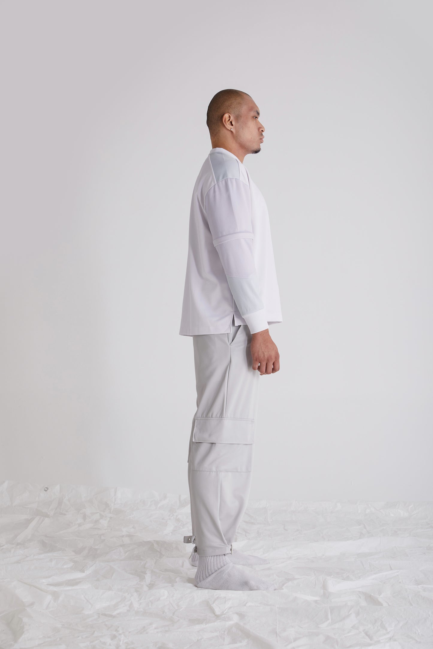 Detail shot of waistband loops and side welt pocket on wide leg trousers